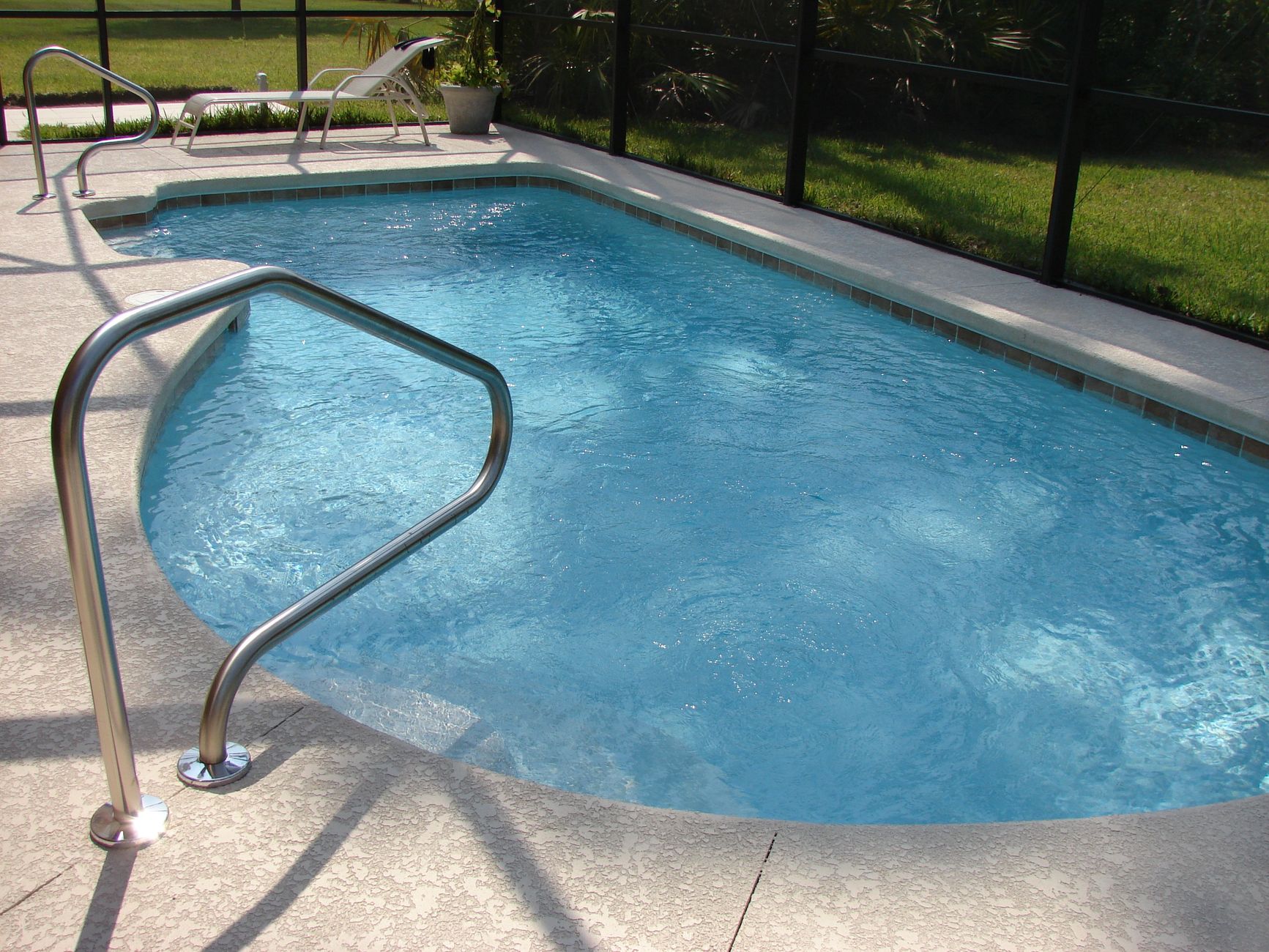 Clean, sparkling backyard swimming pool in the Port St Lucie sun after proper maintenance.