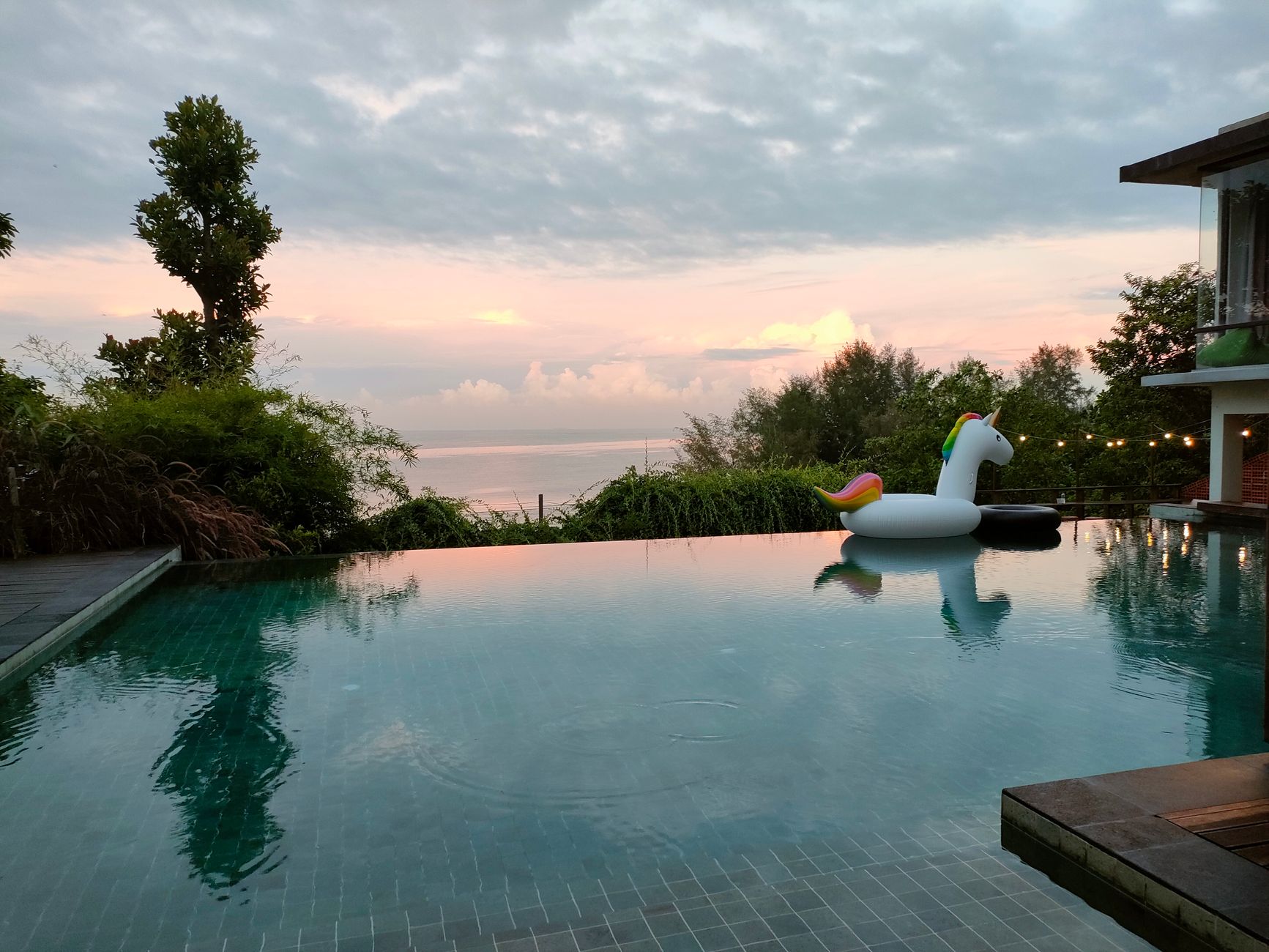 Sunset view over a calm infinity-edge pool with a floating unicorn, the relaxed payoff after fast, reliable pool service.