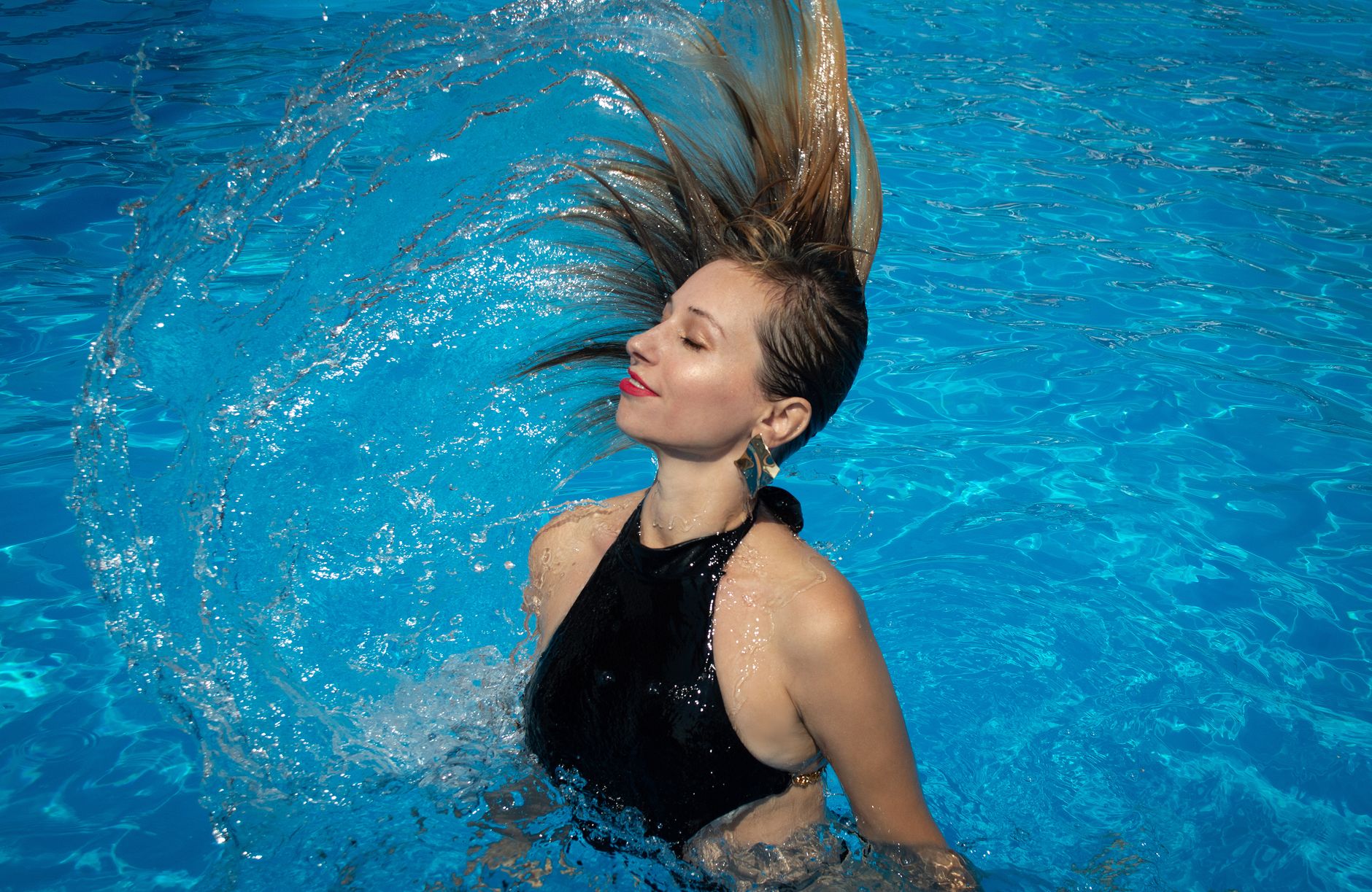 Woman enjoying clear, sunlit pool water in Port St Lucie, the payoff of choosing the right weekly or monthly pool service plan.